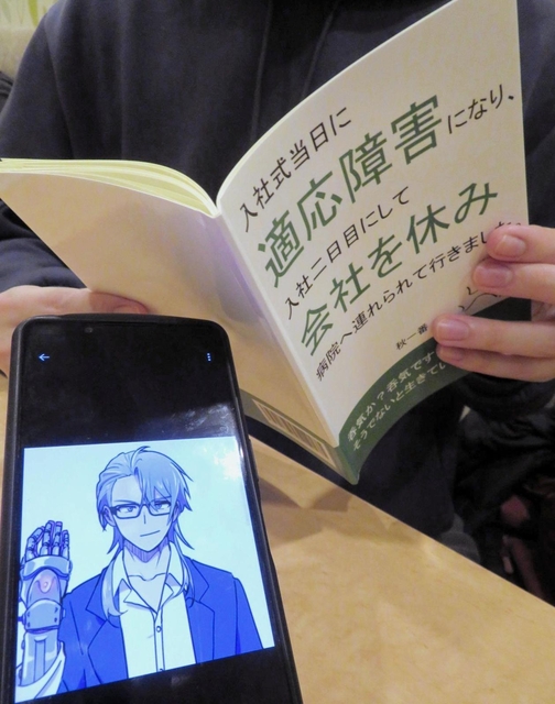 体験を記した著書を手にする秋一番さん。手前は、ＳＮＳで使用している自身のキャラクター＝大阪市内