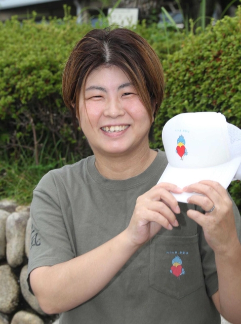 性的少数者の情報発信に取り組む東口由佳さん。手に持つのはオリジナルキャラクターを描いた帽子＝芦屋市内