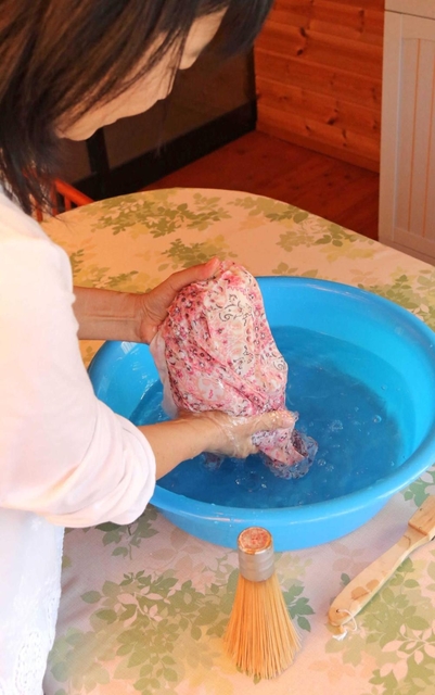 たらいを使い水洗い洗濯を実演する高見明美さん＝加西市内