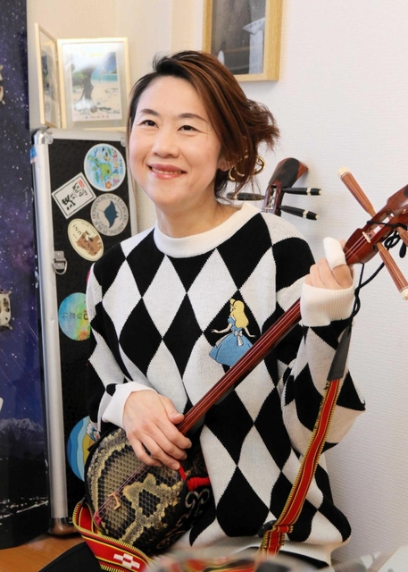 三線を手に笑顔を見せる野口由美子さん＝神戸市内