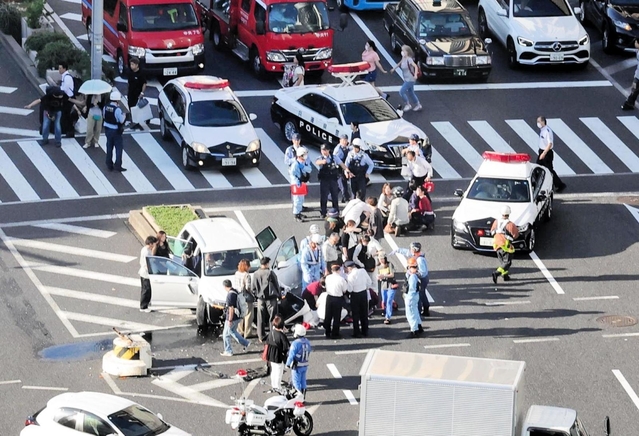 神戸国際会館前の交差点で事故処理にあたる警察官ら＝１日午後３時４６分、神戸市中央区御幸通８、フラワーロード