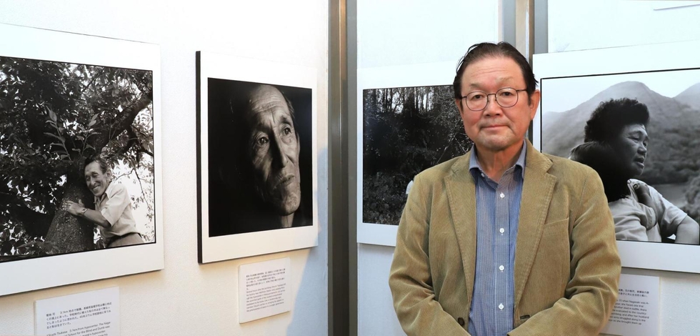 「被爆ろうあ者」の姿を記録した写真を展示している豆塚猛さん＝尼崎市昭和通２、市総合文化センター