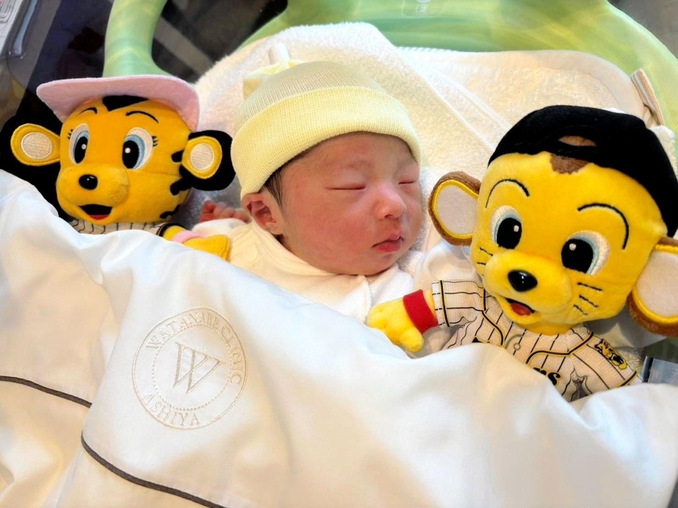 震災で亡くなった父も汀さんもプロ野球阪神タイガースの大ファン。マスコットに囲まれ眠る桧凪ちゃん（小島汀さん提供）