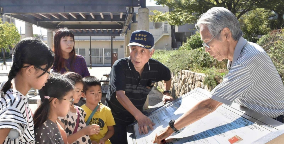 千歳公園の防災機能を説明する（右から）田村勝太郎さん、崔敏夫さん＝神戸市須磨区