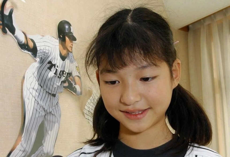震災で亡くなった父・謙さんの遺品のタイガース帽を手にする小島汀さん＝神戸市東灘区本庄町１、レインボーハウス