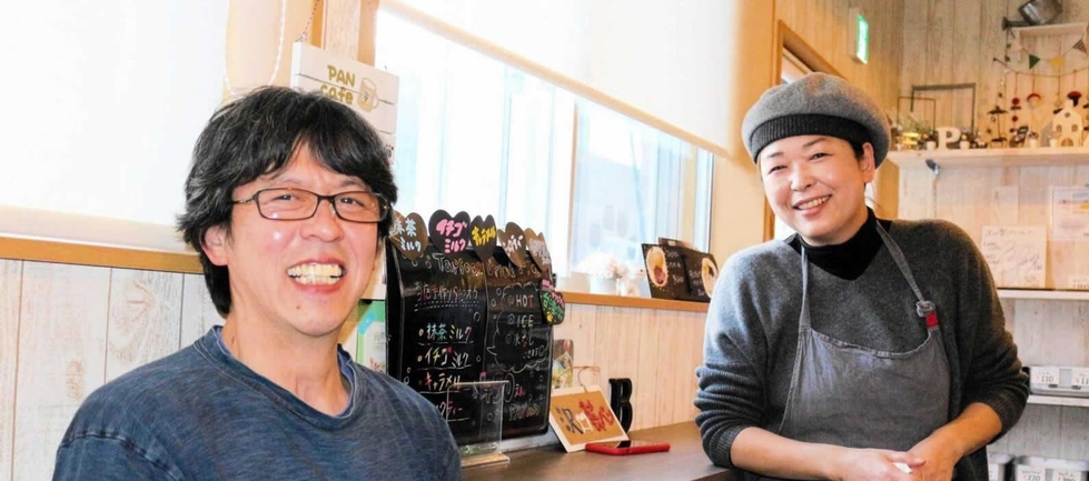 パン工場に併設したカフェで、小島汀さんとの交流を語る澤口和彦さんと、玉枝さん＝２０２０年、釜石市鵜住居町