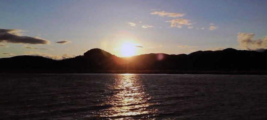 石巻市の北上川からのぞむ夕日（提供）