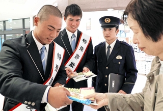 買い物客に啓発チラシを手渡す神戸国際大学付属高校の野球部員ら＝ブルメール舞多聞