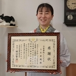 感謝状を受けた上月香織さんと、女性を慰めた看板猫の「宇治ちゃん」＝神戸市灘区城内通３