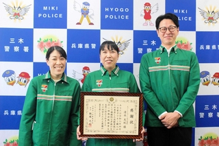 同僚らに囲まれ、感謝状を手に笑顔を見せる清水友紀さん（中央）＝三木署