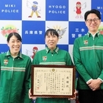 同僚らに囲まれ、感謝状を手に笑顔を見せる清水友紀さん（中央）＝三木署