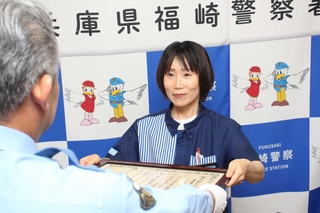 感謝状を受けたローソン神崎粟賀店の竹下真由美店長＝福崎署