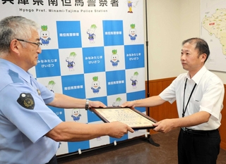 西藤勉署長（左）から感謝状を受け取る山本弘美さん＝南但馬署