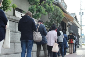 コロナ対策で間隔を置きながらできた長蛇の列＝きねや菓舗