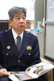 写真を見ながら当時を振り返る道家利幸署長＝三田署