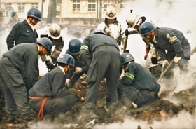 くすぶる焼け跡で行方不明者を捜索する警察官や消防士＝１９９５年１月１９日、神戸市長田区