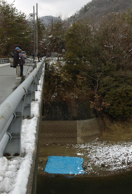 黒郷橋から見えるブルーシートで覆われた人骨発見現場＝２０１１年２月、三田市小野