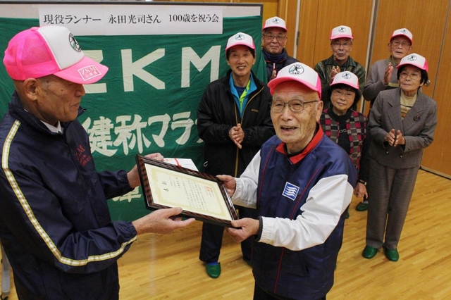 メンバーからのお祝いの表彰を受ける永田さん＝三輪会館