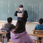 駐在所での仕事を説明する藤原警部補＝広野小学校
