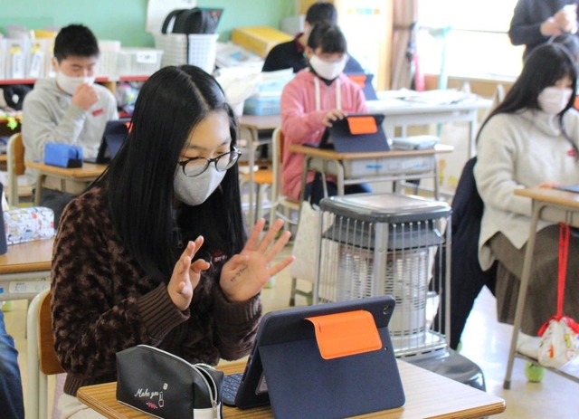 手を振ってあいさつを交わす児童＝藍小学校