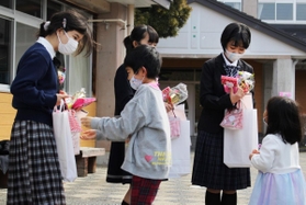 卒業生にプレゼントを贈る在校生＝母子小学校