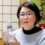 「電源がない場所での充電のために、電池も重要」と説明する益田紗希子さん＝大阪市