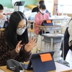 手を振ってあいさつを交わす児童＝藍小学校