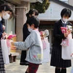 卒業生にプレゼントを贈る在校生＝母子小学校