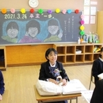 担任の山崎丈教諭が描いた似顔絵を背に思い出を語る卒業生＝母子小学校