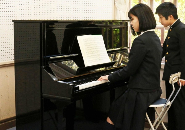 石井勝さんの遺品のピアノを演奏する部員＝三田学園