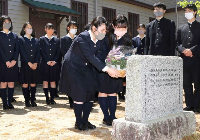 顕彰碑に花を手向ける吹奏楽部の部員ら＝三田学園
