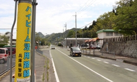 ハイビーム活用路線に指定されたことを知らせる電柱幕＝三田市下里