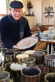 お気に入りの皿を持つ定金さん＝三田市下井沢