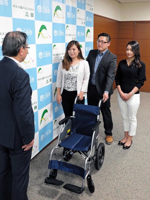 森哲男市長に車いすを寄贈する（右から）松本唯さん、小南貴洋さん、井ノ上奈々さん＝三田市役所