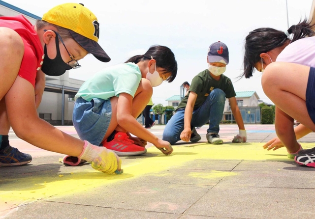 チョークを手に作業する児童＝志手原小学校