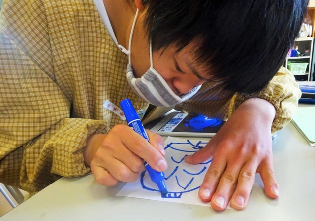 魚の絵を描く上野ケ原特別支援学校の生徒（提供）