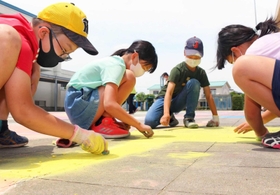 チョークを手に作業する児童＝志手原小学校