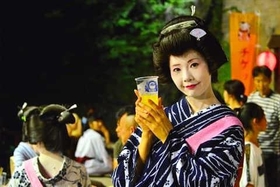 阪神・淡路大震災後のイベントでビールを提供する芸妓の女性