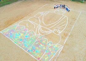白線を使って実物大の大仏を描いた児童ら＝高平小学校（サンフォトタカハシ提供）