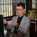 書斎スペースでテレビ電話を使って話す太野さん＝三田市