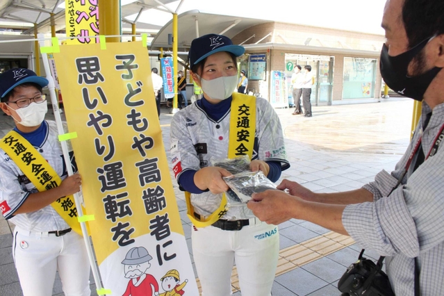 啓発グッズを手渡す兵庫ブルーサンダーズのメンバー（左から２人）＝三田市駅前町