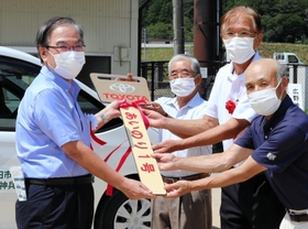 運行開始式で鍵の模型を手渡す森哲男市長（左）ら＝三田市上青野