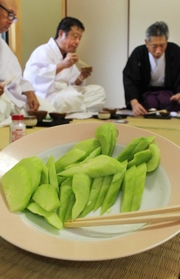 神事の後でキュウリを食す氏子ら＝三田市下田中