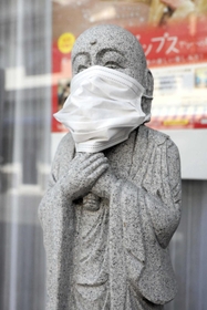 「平瀬楽器」前にあるマスク姿の地蔵＝三田市中央町