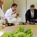 神事の後でキュウリを食す氏子ら＝三田市下田中