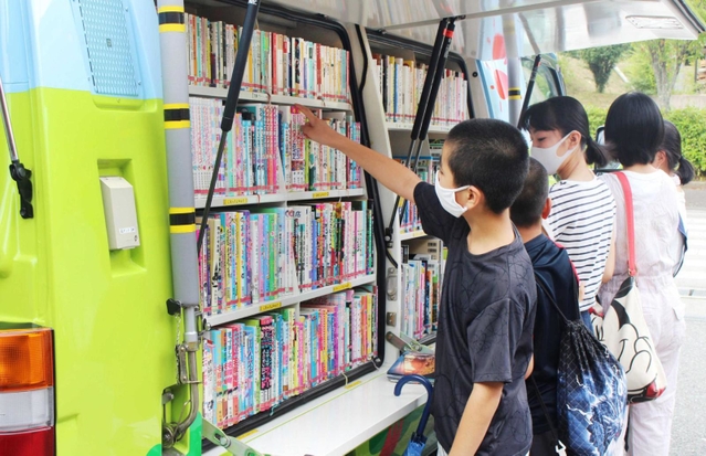 車に積まれた本をじっくり眺める＝母子小学校