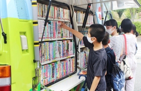 車に積まれた本をじっくり眺める＝母子小学校