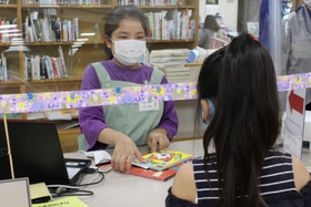 カウンターで返却期限を伝えて本を貸し出す＝三田市立図書館