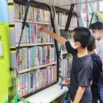 車に積まれた本をじっくり眺める＝母子小学校