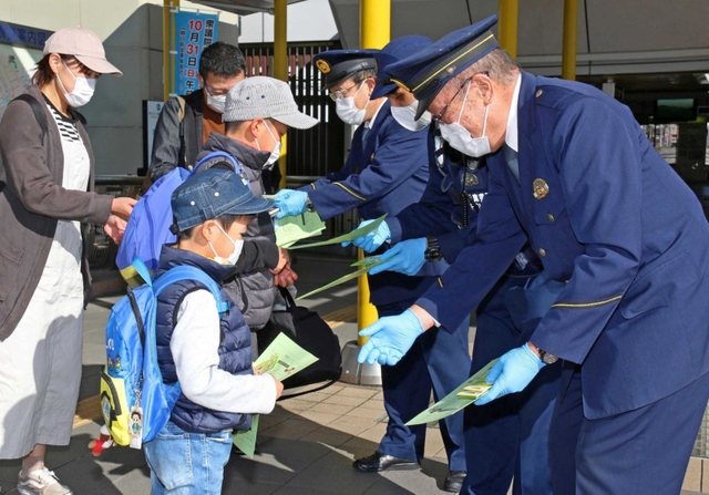 チラシを配布する地域課員＝三田市駅前町（撮影・小森有喜）